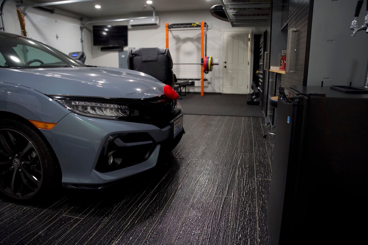 A garage with upgraded floors using Leggari's Hardwood Overly System to achieve the look of hardwood with concrete overlay.