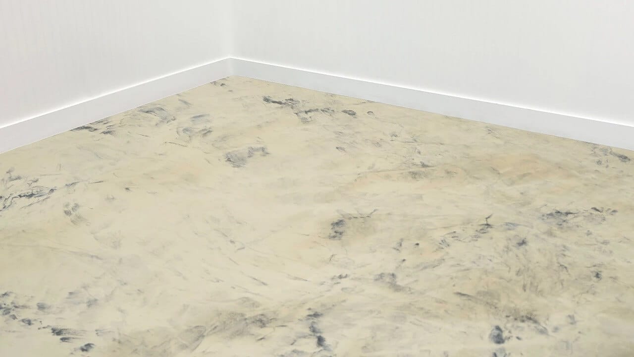 A metallic epoxy garage floor that features a Khaki Base with Black Leggari Effects Highlights. The Leggari Effects Highlights are dripped out in a random pattern and then blended using a squeegee.