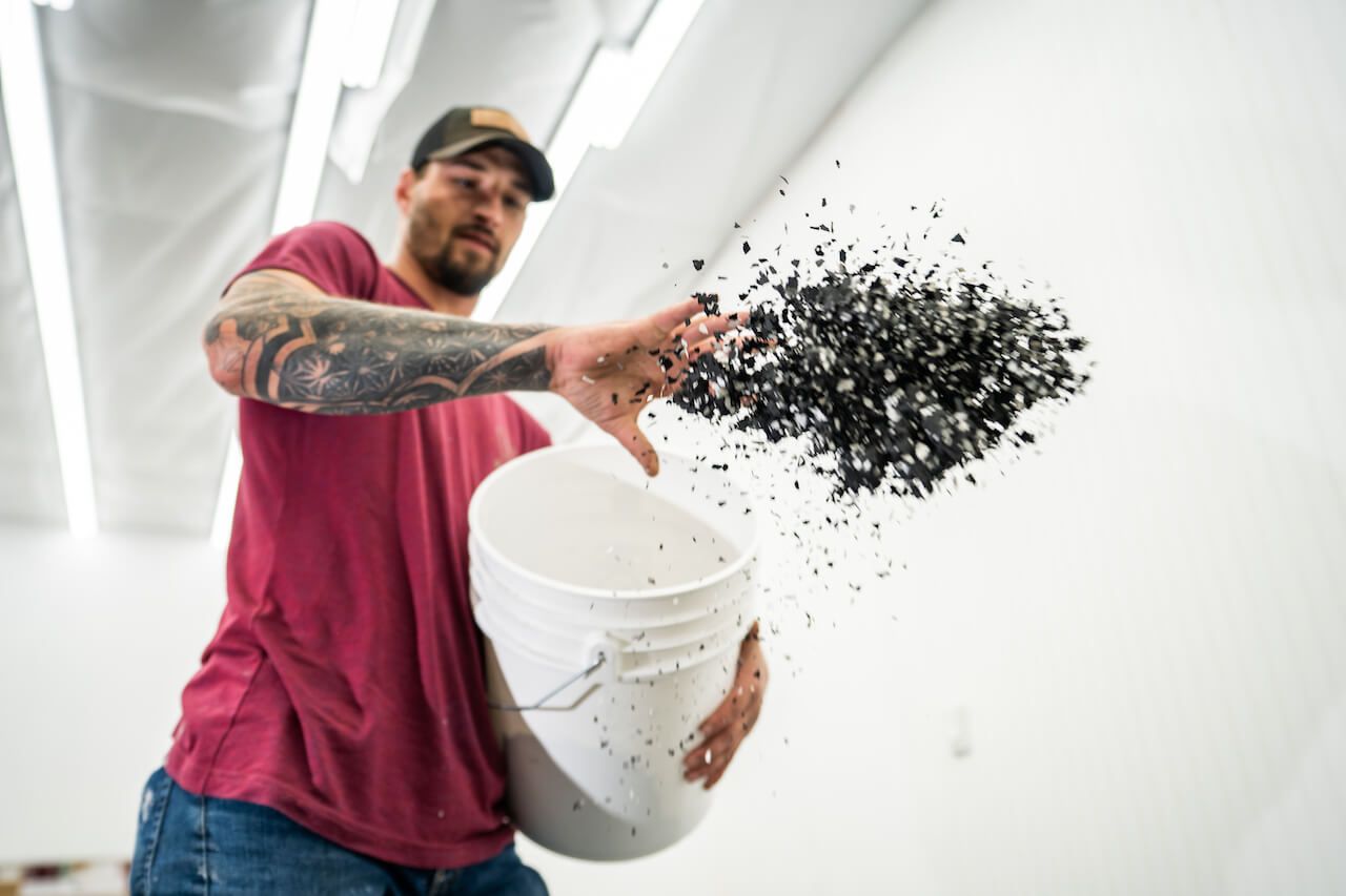 A contractor broadcasting decorative flakes on an epoxy floor.